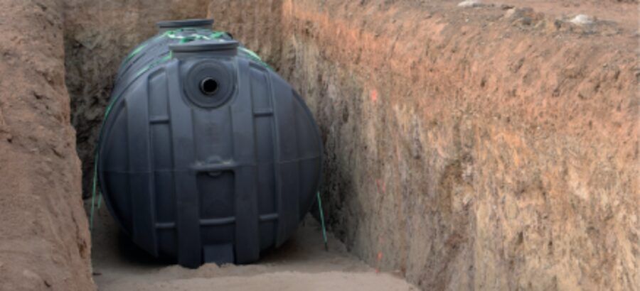 Depósito enterrable de color negro colocado en el fondo de una zanja excavada